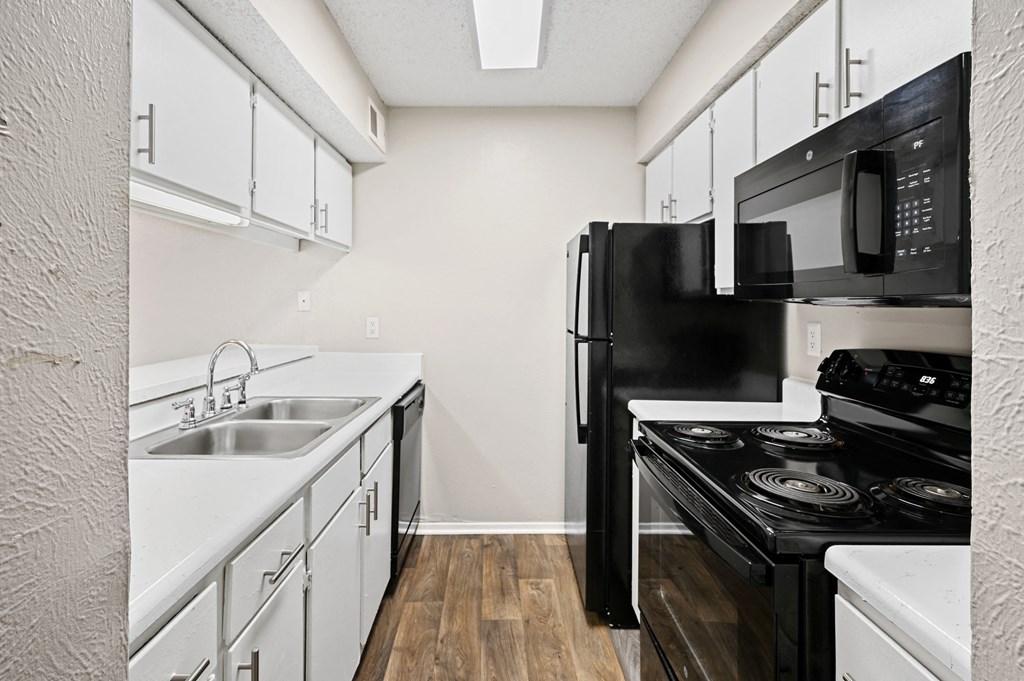 a kitchen with white cabinets and black appliances
