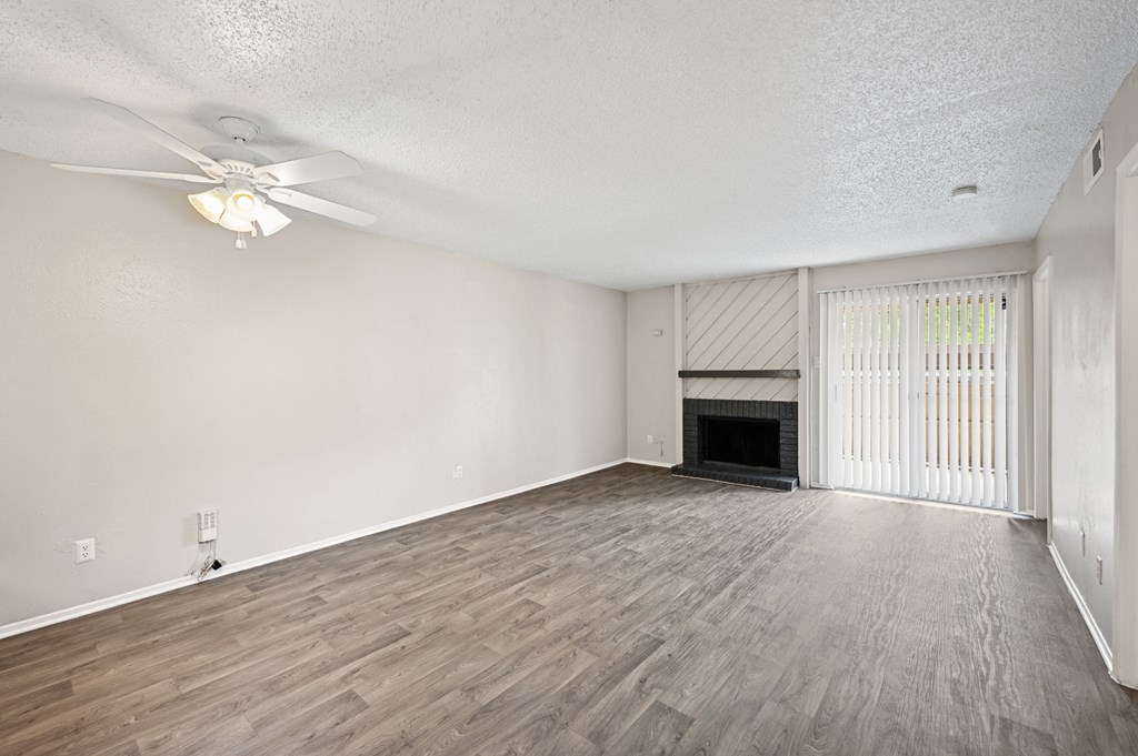 a living room with a fireplace and a ceiling fan