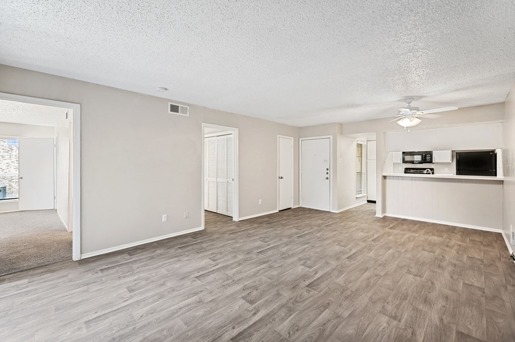 an open living room and kitchen with a ceiling fan