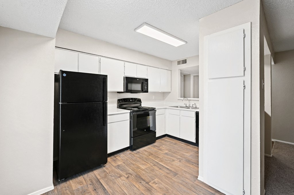 a kitchen with white cabinetry and black appliances