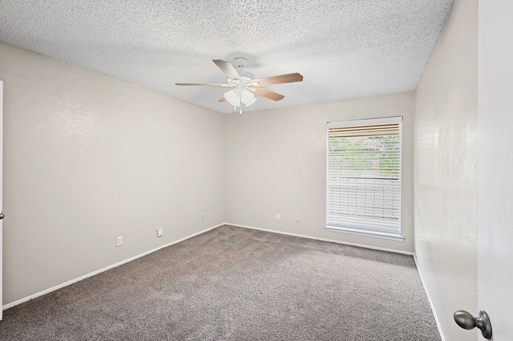 a bedroom with a ceiling fan and a window