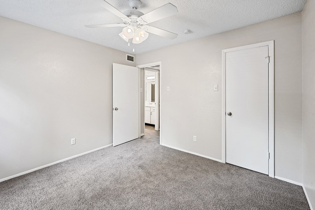 a bedroom with white walls and carpet
