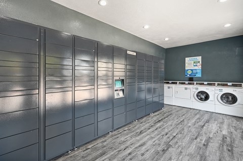 a laundry room with gray lockers and white washers and dryers