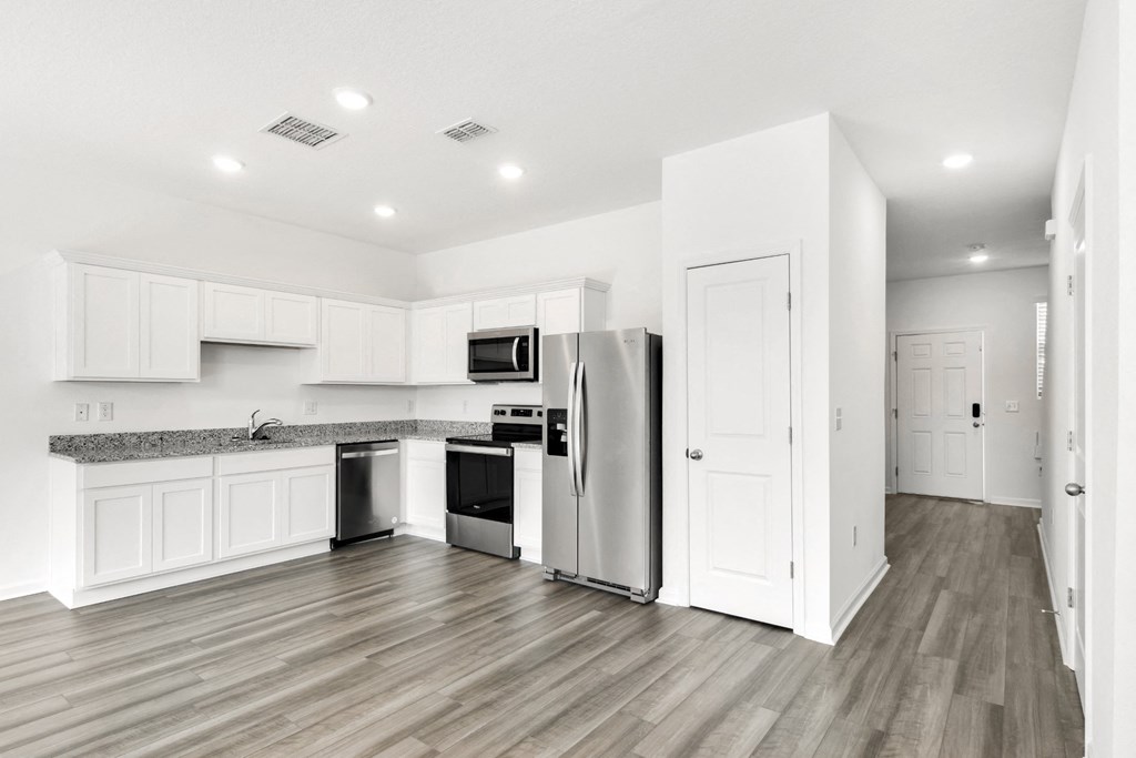 a kitchen with white cabinets and stainless steel appliances