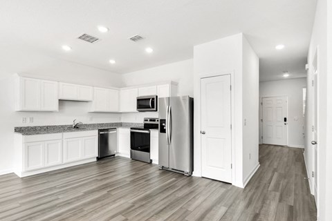 a kitchen with white cabinets and stainless steel appliances