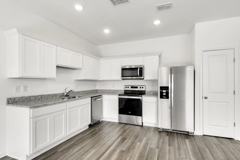 a kitchen with white cabinets and stainless steel appliances