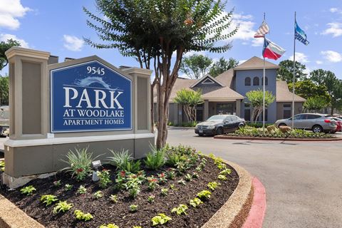 a parking lot with a sign that says park at woodlawn apartments