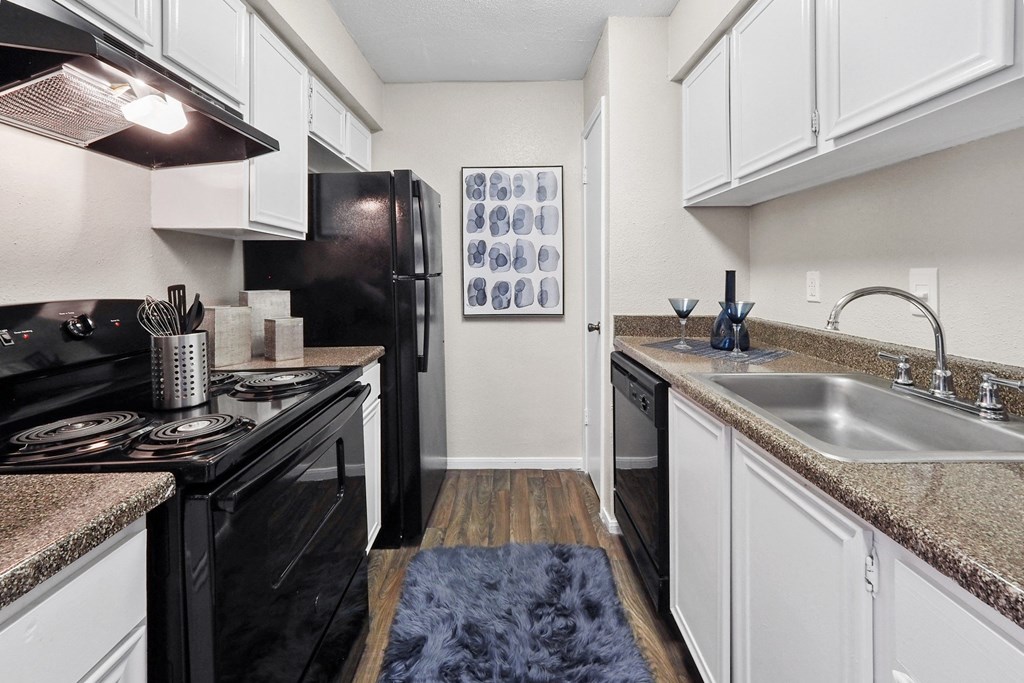 a kitchen with white cabinets and black appliances