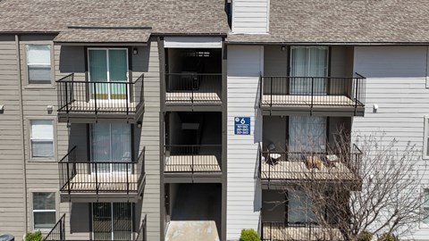 An apartment building with private balconies at The Park on Preston Apartments in Dallas, TX