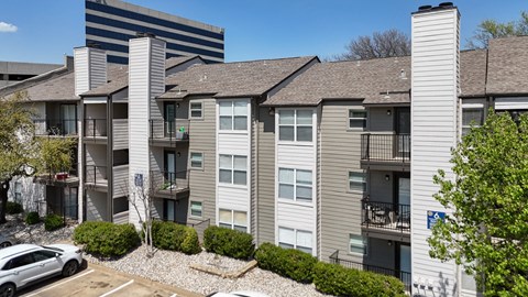 An apartment building with gray and white walls and balconies at The Park on Preston Apartments in Dallas, TX
