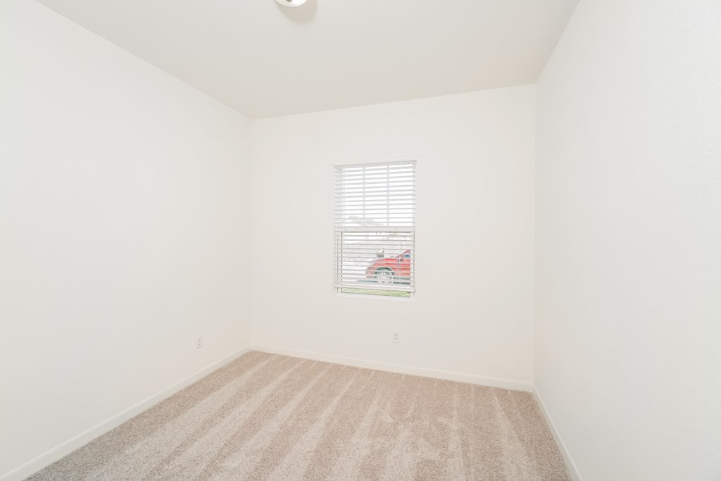 a bedroom with white walls and a window with a red car in it at Beacon at Meridian, San Antonio