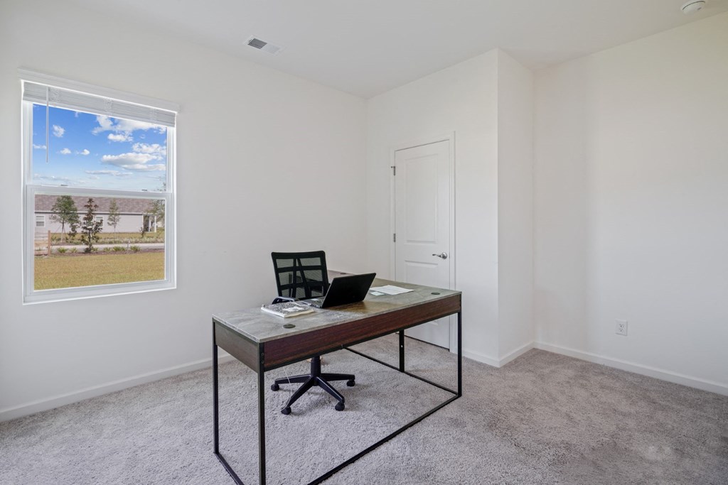 a home office with a desk and a window