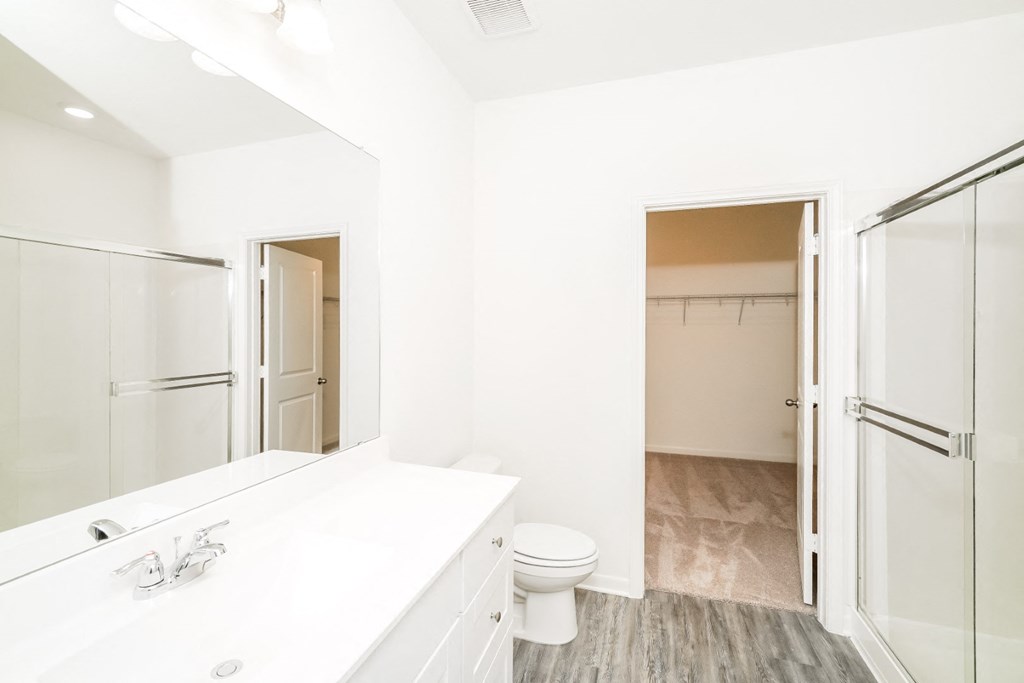 a bathroom with a white sink and toilet and a shower with a glass door at Beacon at Meridian, San Antonio Texas