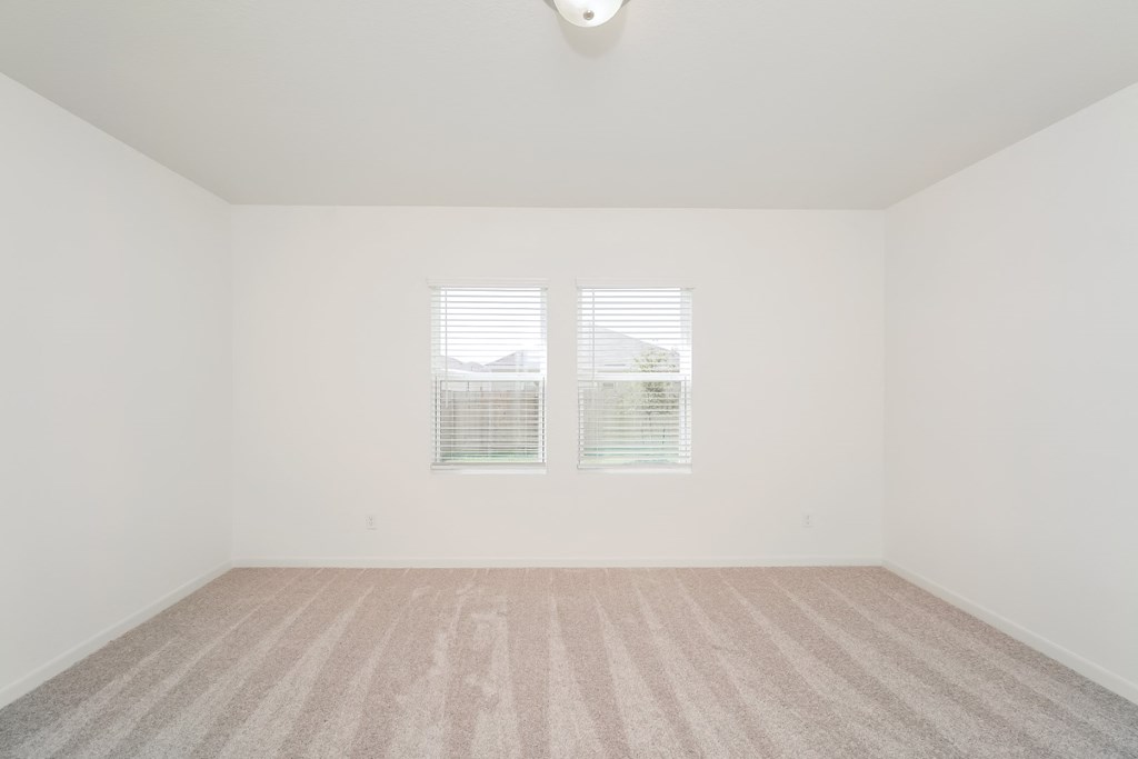 a bedroom with two windows and a carpeted floor at Beacon at Meridian, San Antonio, TX 78245