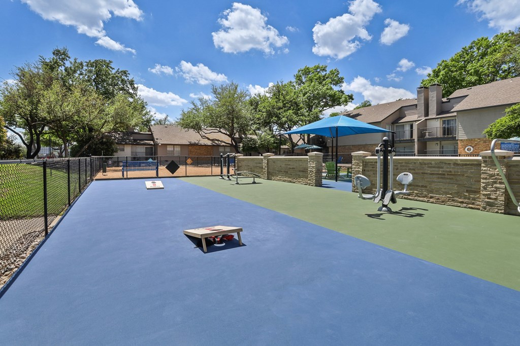 a dog park with a trampoline and agility course at the whispering winds apartments in pear