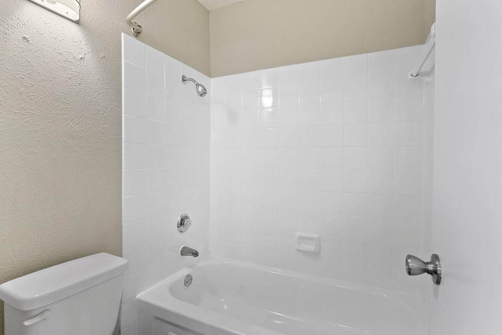 a bathroom with a white tub and a white toilet