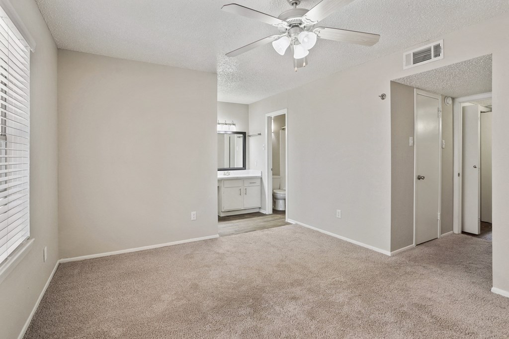an empty bedroom with a ceiling fan