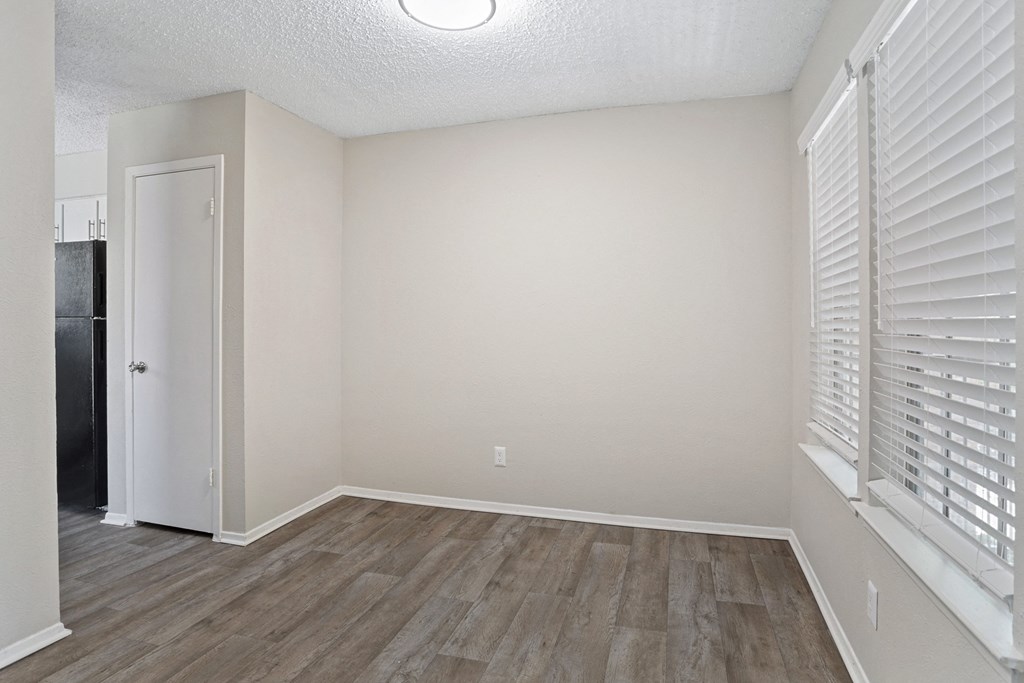 a bedroom with hardwood floors and a large window