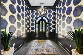 a hallway with blue and yellow wallpaper and a chandelier