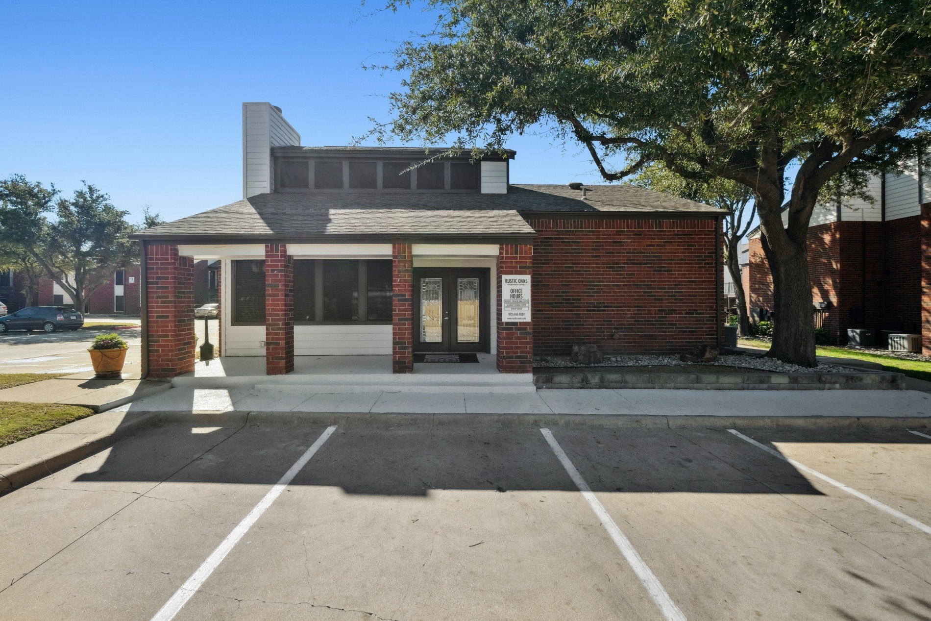 A small brick building with a black roof and a sign on the front.