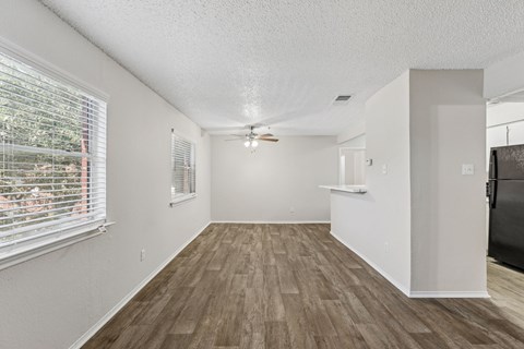 A room with wooden flooring and white walls.
