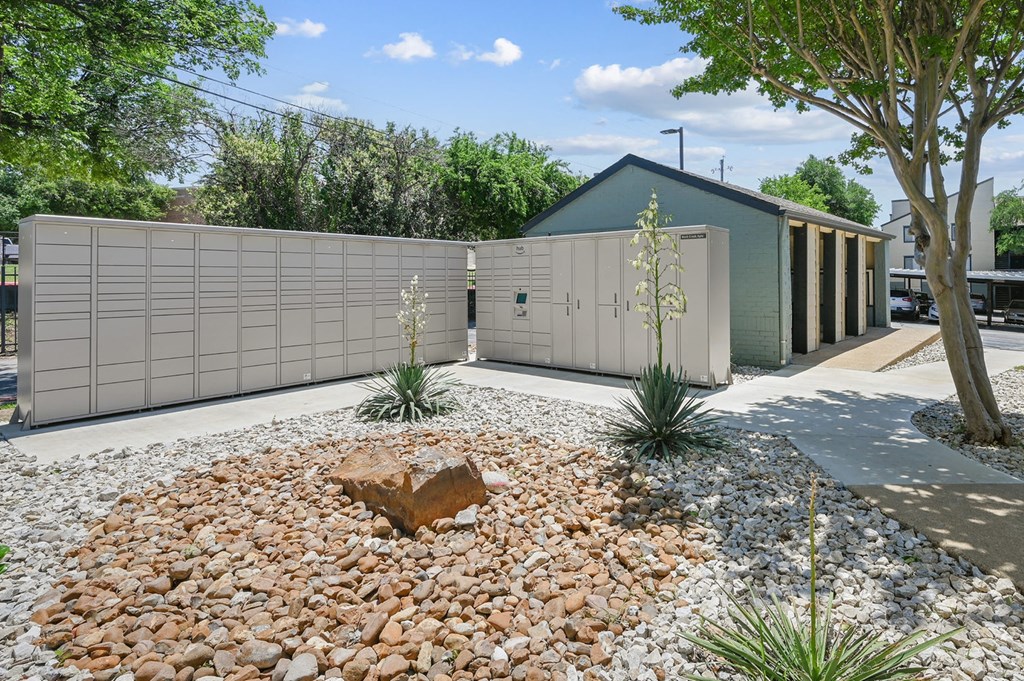 a house with a fence and a rock garden in front of it