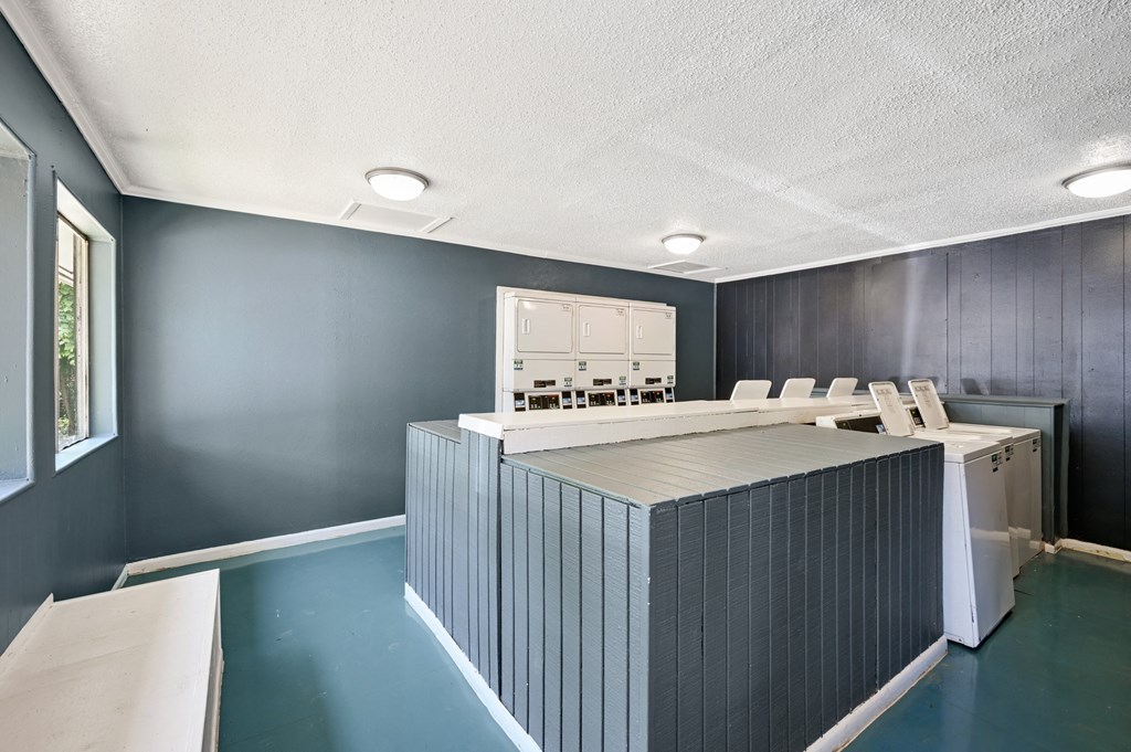 a room with a large table and chairs in front of a window