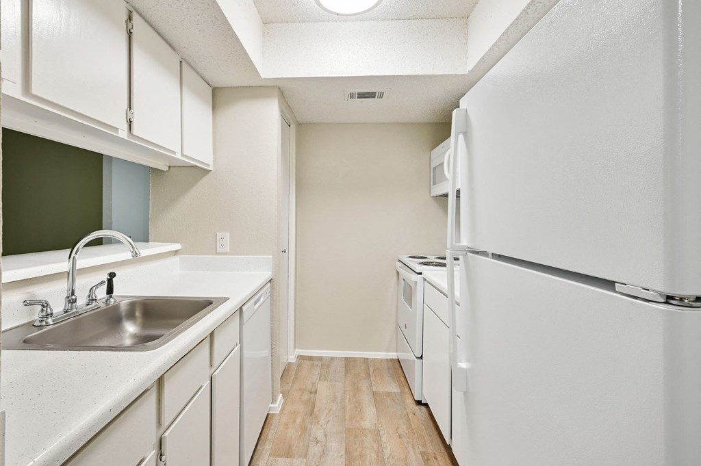 a kitchen with white cabinets and white appliances