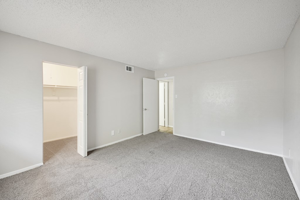 a bedroom with a carpeted floor and an open door to a closet