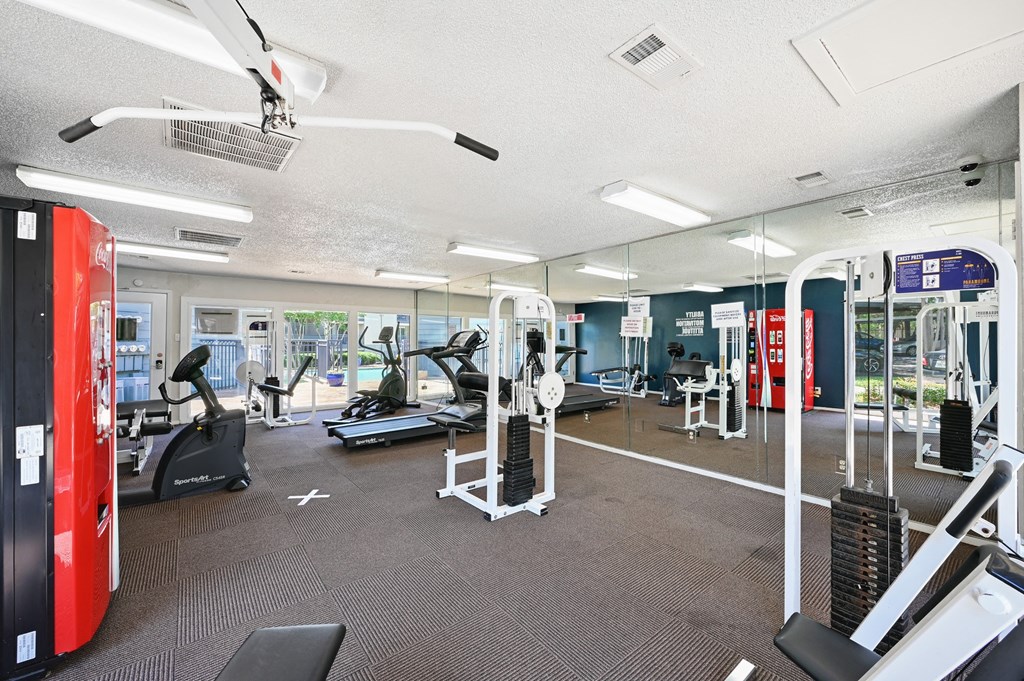a spacious fitness center with cardio machines and other exercise equipment