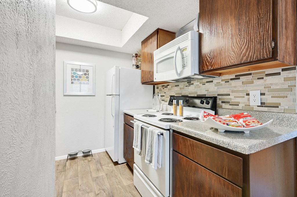 a kitchen with a white refrigerator freezer next to a stove top oven