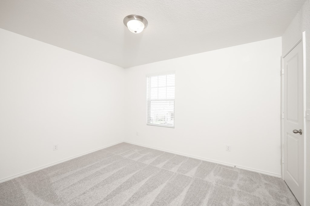 a bedroom with white walls and carpet