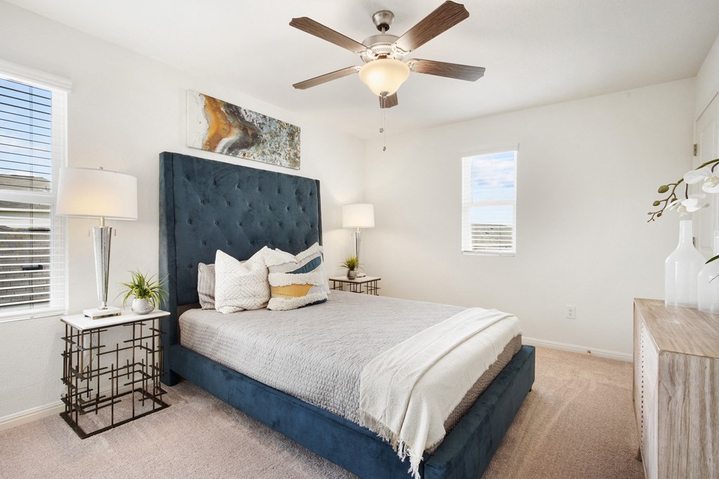 a bedroom with a large bed and a ceiling fan
