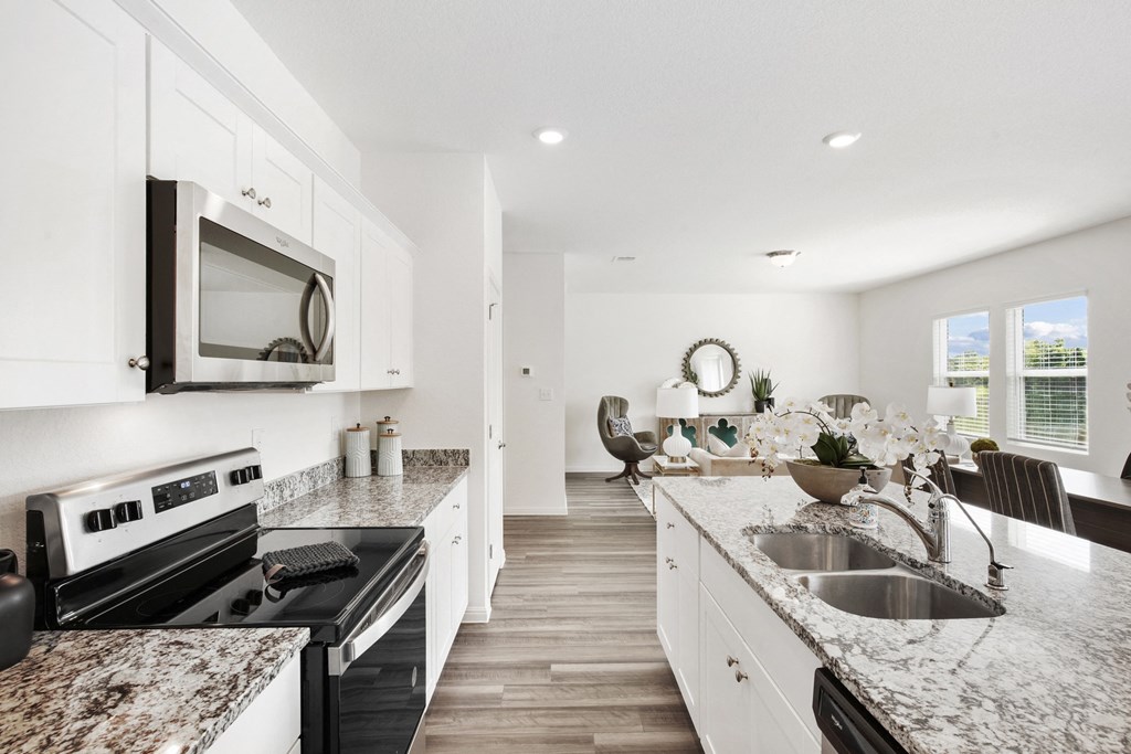 a kitchen with white cabinets and granite countertops