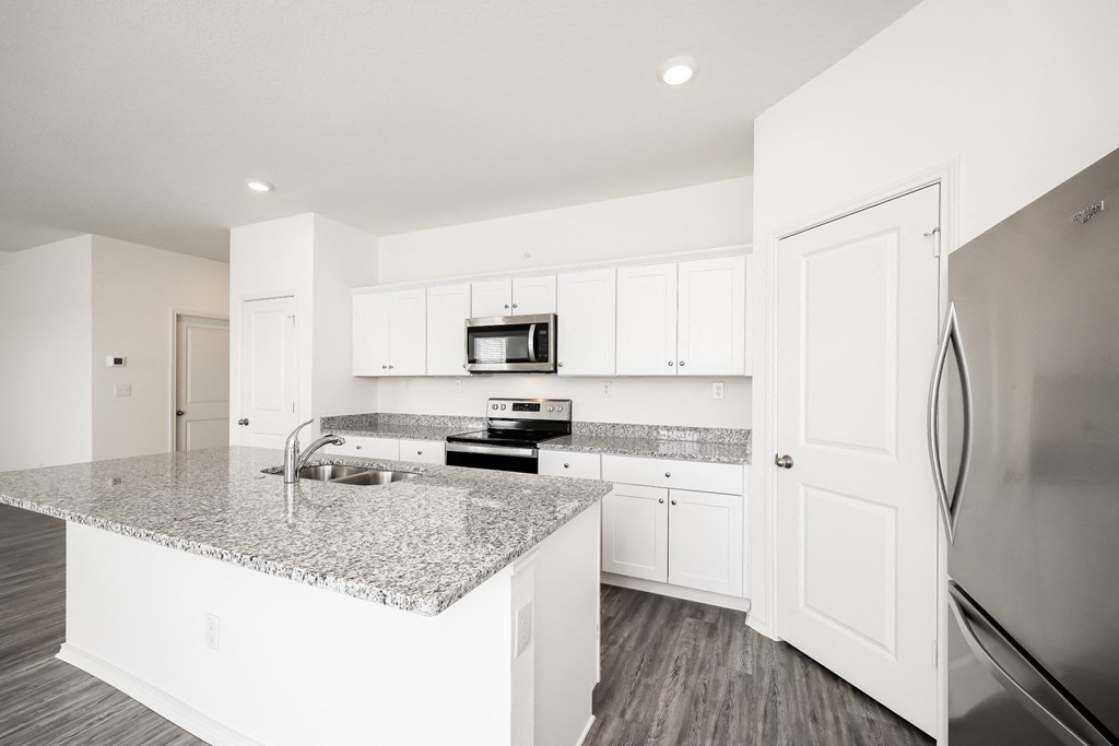 a kitchen with white cabinets and a granite counter top at Beacon at Meridian, San Antonio, 78245