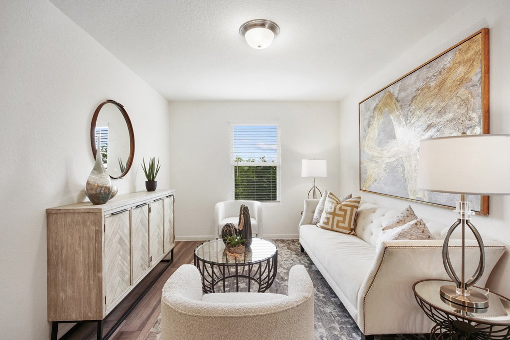 a living room with a white couch and two chairs