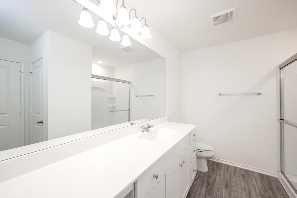 a bathroom with a large mirror and a toilet at Beacon at Meridian, Texas, 78245