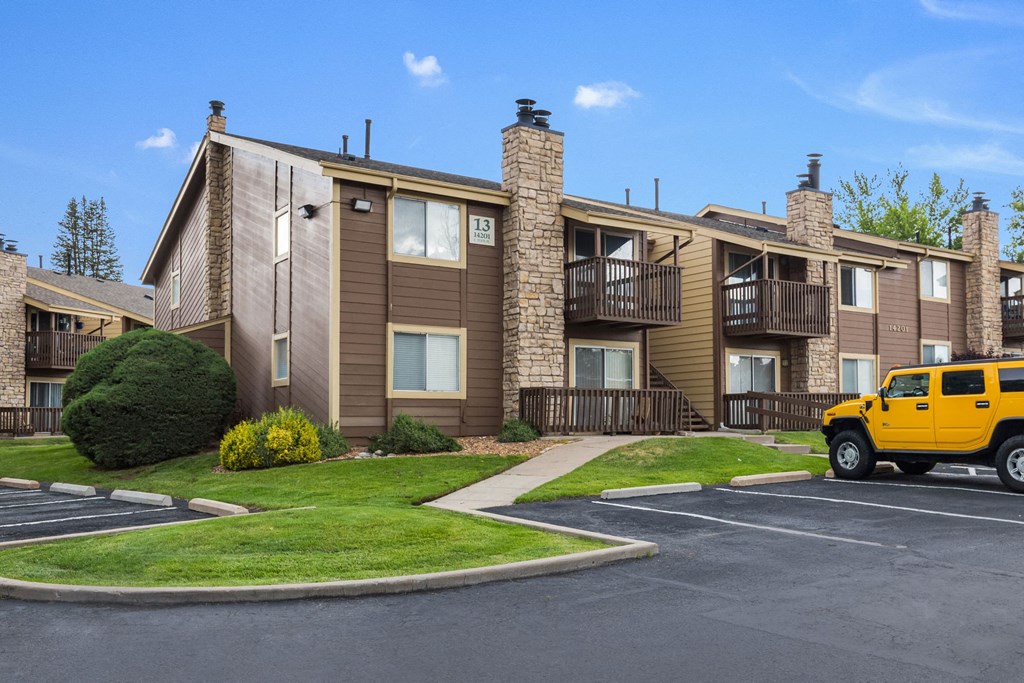 a yellow truck parked in front of an apartment building