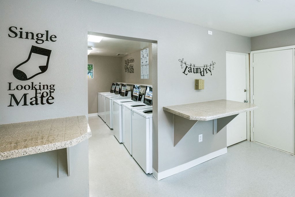 a laundromat with a row of machines and a counter with a counter top