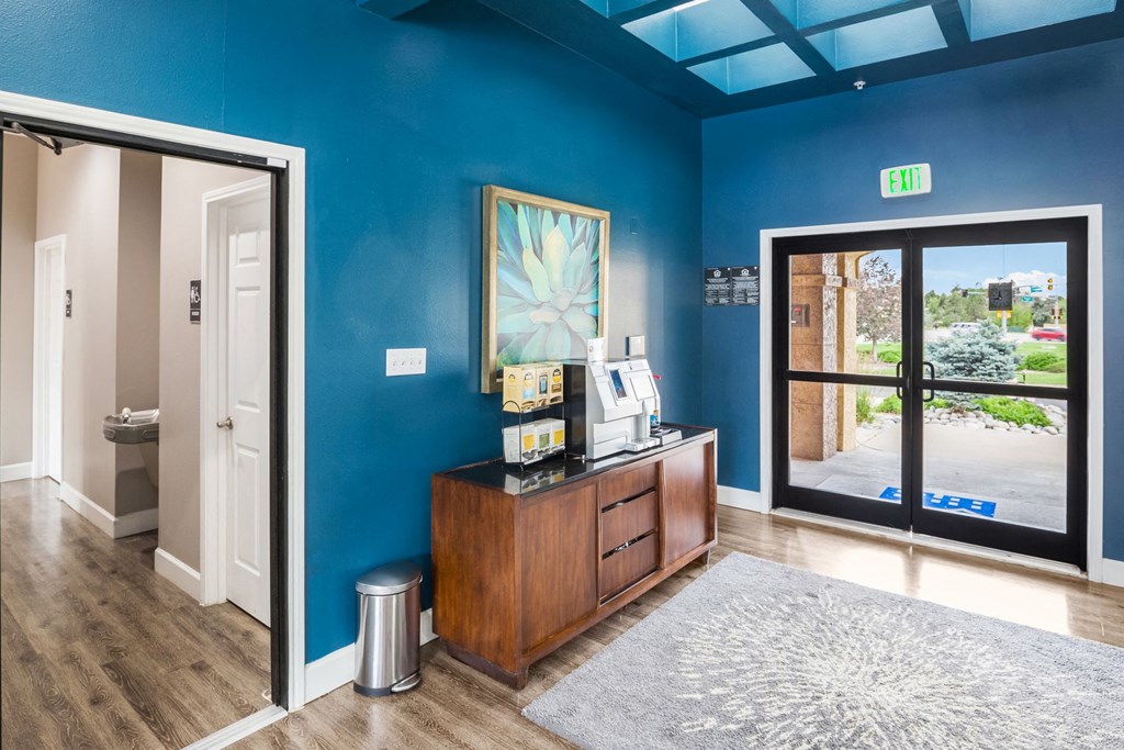 a lobby with a blue wall and a door to the street