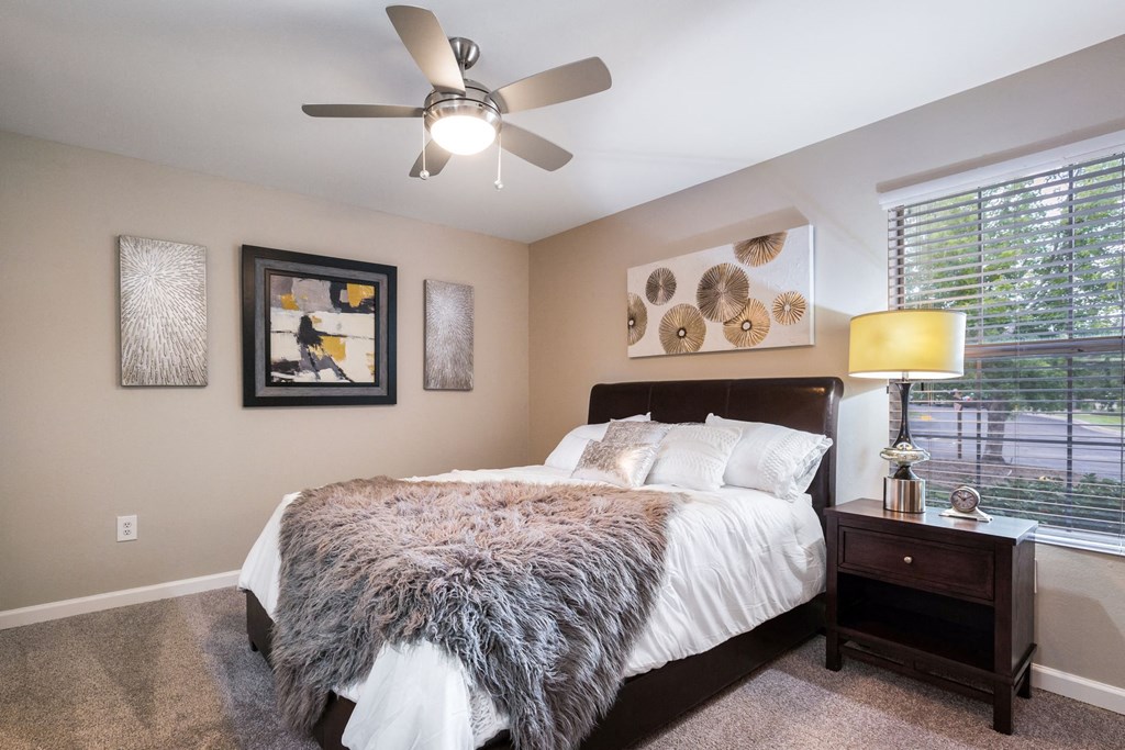 a bedroom with a large bed and a ceiling fan