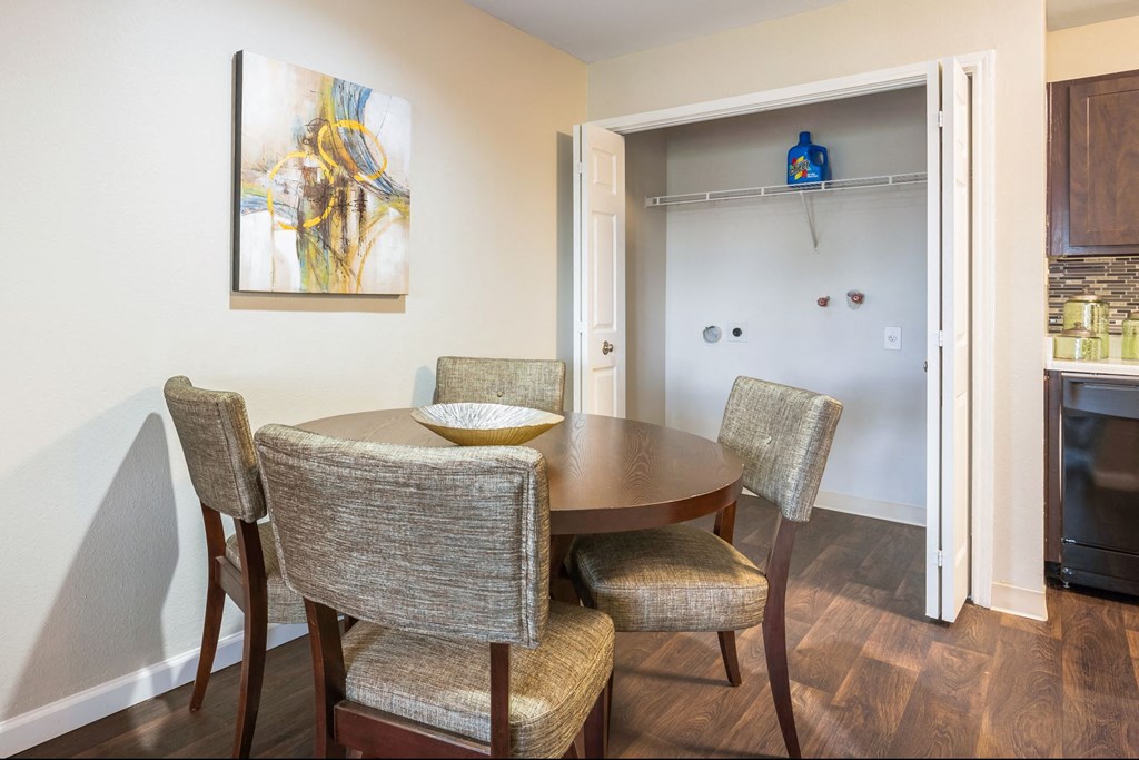 a dining room with a table and chairs and a refrigerator