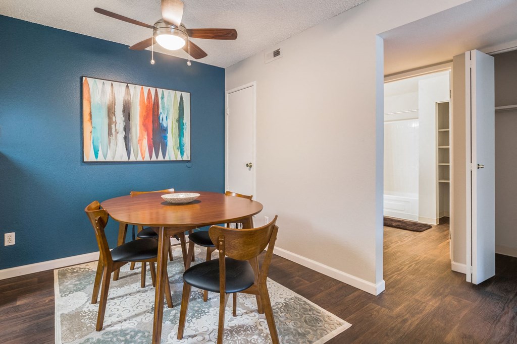 a dining room with a table and chairs and a ceiling fan