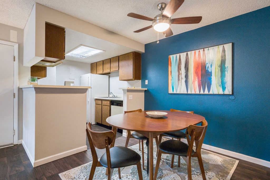 a dining room with a table and chairs next to a kitchen