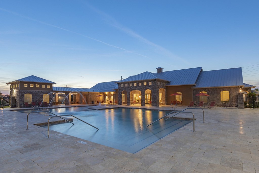 a swimming pool in front of a house with a blue sky