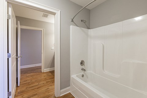 a bathroom with a tub and a shower and a door