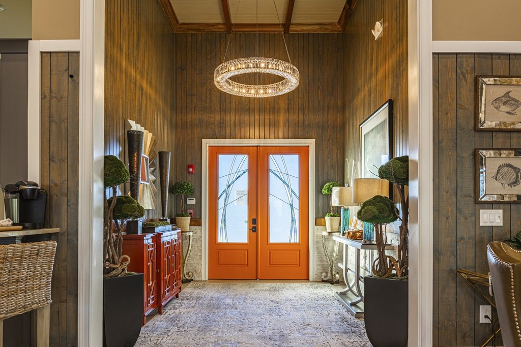 a hallway with an orange door and a pendant light