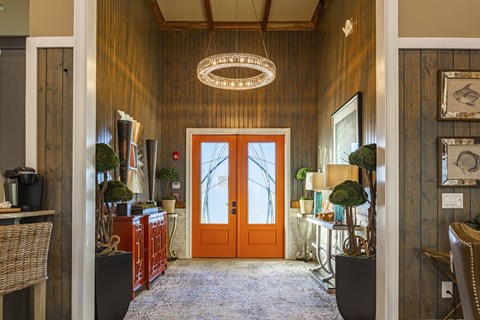 a hallway with an orange door and a pendant light
