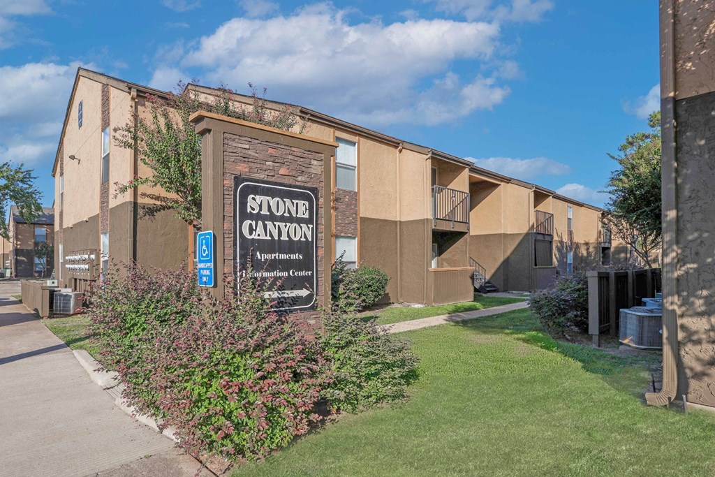 Stone Canyon Apartments sign with apartment buildings behind it at Stone Canyon apartments in Shreveport, LA.