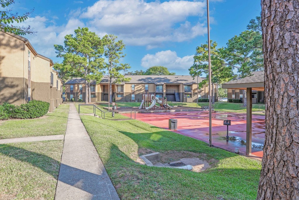 Large playground area with slides surrounded by apartment buildings at Stone Canyon apartments in Shreveport, LA.